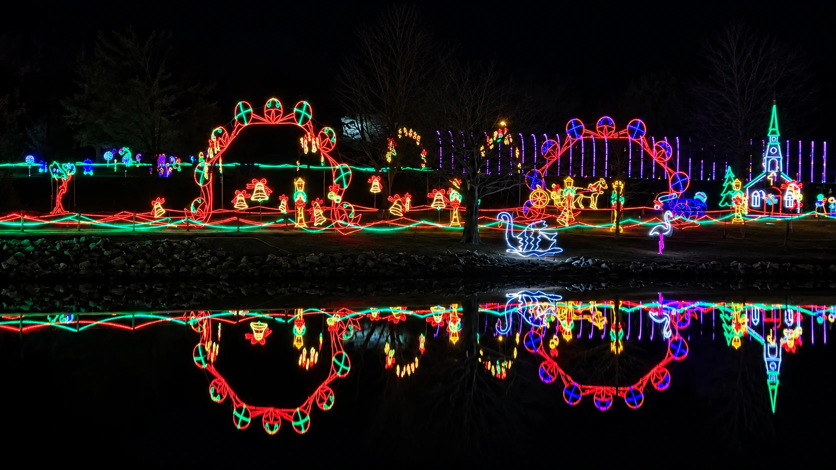 Holiday displays reflected in still pond water at the Festival of Lights.