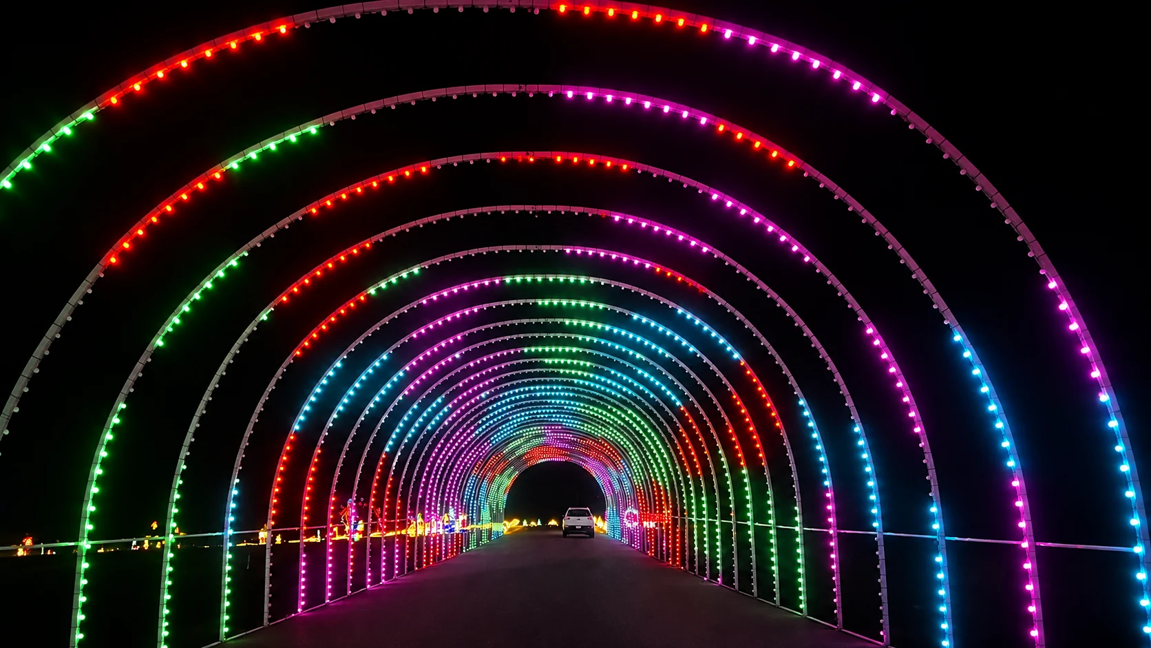 A rainbow of illuminated arches stretching into the night along the Festival of Lights route.